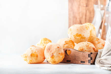 Appetizing homemade golden cheese buns on gray kitchen table background, selective focus. Magazine style. Place for textの写真素材
