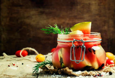 Marinated or pickled watermelon in a glass jar, vintage wooden background, selective focusの写真素材