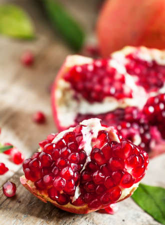 Ripe red pomegranate on an old wooden table, selective focusの写真素材