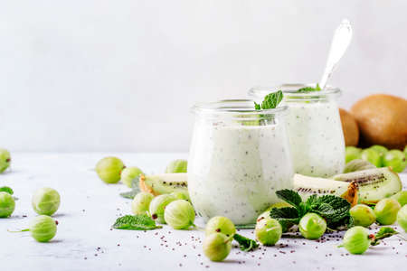 Smoothies from gooseberry, kiwi and yogurt with chia seeds, gray background, selective focusの写真素材