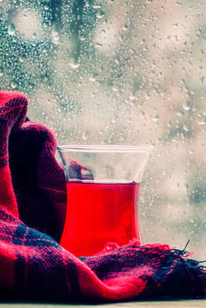 Red tea from China rose in the Islamic glass in the window on a rainy spring weather, selective...