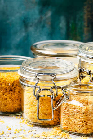 Assorted cereals and grains in glass jars for storage, selective focus