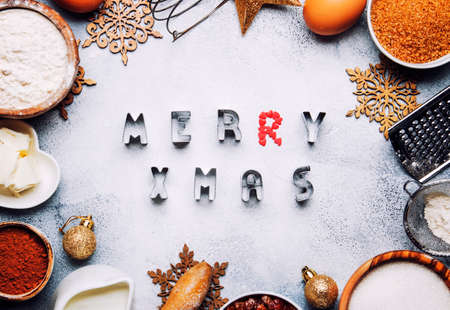 Christmas or New Year composition with ingredients for baking or cookies, with golden snowflakes, Christmas balls, on gray background, with inscription merry xmas, frame, top viewの写真素材