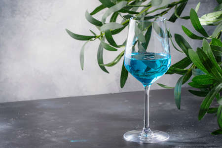 Exotic blue wine, trendy non-classical drink in wine glass on gray backgroundの写真素材