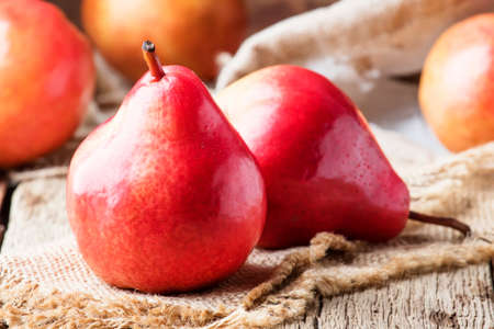 Ripe red pears on rustic wooden background, selective focusの写真素材
