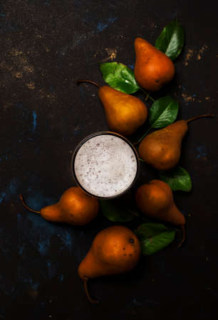 Homemade pear cider or beer with foam, dark background, top viewの写真素材