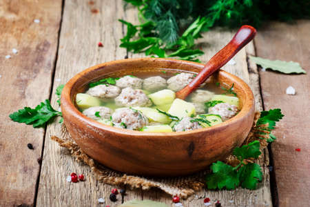 Homemade soup with chicken meatballs and potatoes, rustic style, old wooden background, selective focusの写真素材