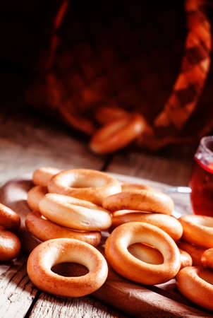 Dried bagels with a cup of black tea on an old wooden table, selective focusの写真素材