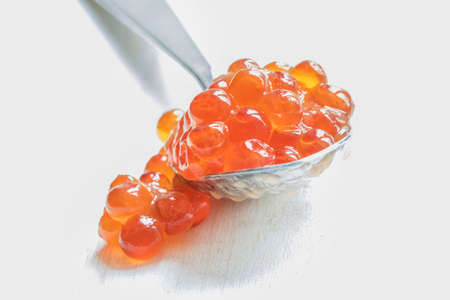 Red caviar in the silver spoon on a white background, selective focus, shallow depth of field