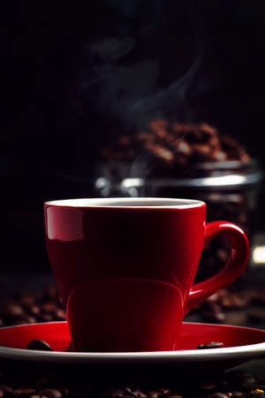 Black coffee with steam in red cup on black kitchen table background, selective focusの写真素材