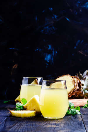 Pineapple juice on dark background, selective focus