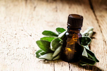 Sage oil in brown bottle on the vintage wooden table, selective focusの写真素材