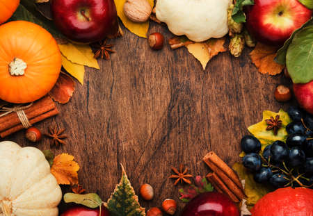 Autumn food top view, Thanksgiving or Halloween background: pumpkins, nuts, fallen leaves and spices on brown wooden background. Seasonal fall background forThanksgiving dinner or harvest festival concept. Copy spaceの写真素材
