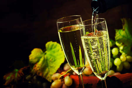 Champagne Pour In Glass, Grapes With Vine, Vintage Wood Background, Selective Focusの写真素材