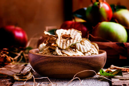 Apple chips, still life in rustic style, vintage wooden background, selective focus