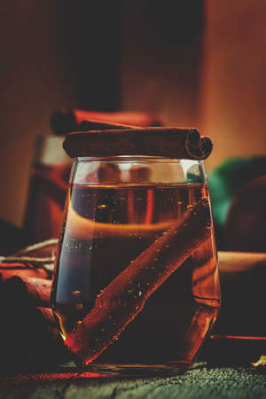 Apple cider with cinnamon, vintage wooden background, selective focus and toned imageの写真素材