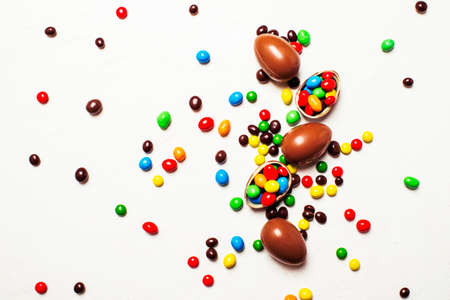 Easter composition with chocolate eggs and colorful candy, white background, top viewの写真素材