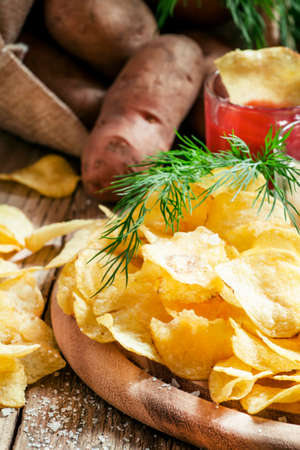 Chips with salt, spices and sauce, vintage wooden background, selective focusの写真素材