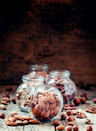 Almonds in jars on a dark wooden background, selective focusの写真素材