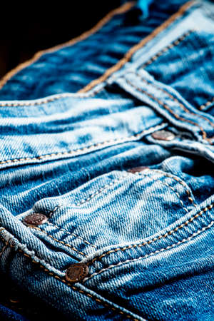 Classic casual blue jeans, pile on a vintage wooden background, selective focusの写真素材