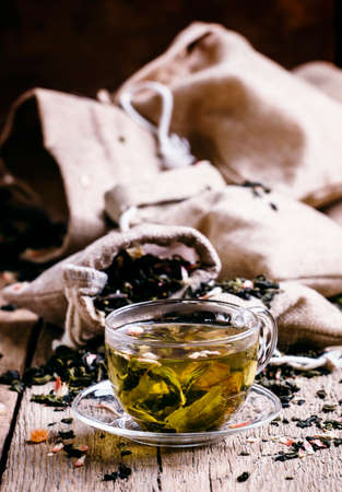 Green Ceylon tea in the cup, old wooden background, selective focusの写真素材