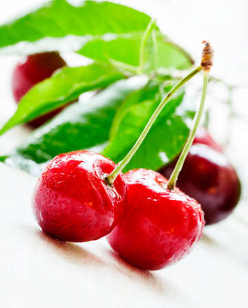 Red sweet cherry, white wooden background, close up, selective focus