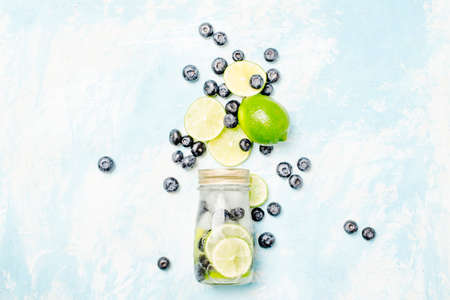Lime-blueberry lemonade with ice in glass bottle, top viewの写真素材
