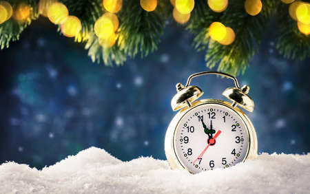 Christmas or New Year background with Golden alarm clock in snowdrifts on blue background with pine...
