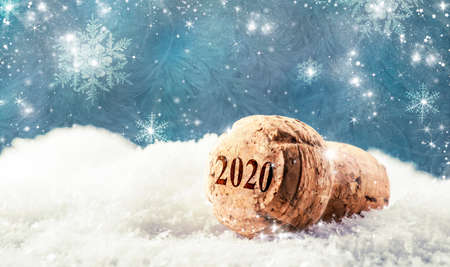 New Year or Christmas concept with champagne cork in snowdrift on blue background with snowflakesの写真素材