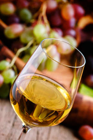 Autumn ice wine, ripe grapes and dried leaves, vintage wooden background, selective focusの写真素材