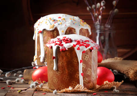 Happy easter! Traditional Russian easter cake Kulich with colored red eggs, decorated with hearts,...