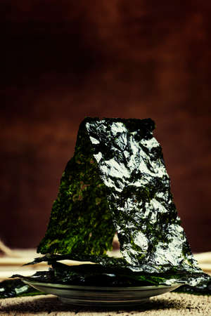 Chips from nori, vintage wooden background, selective focus