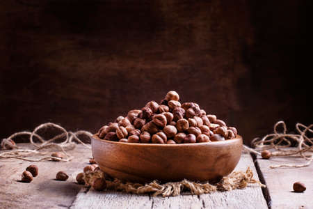 Peeled hazelnuts, vintage wooden background, rustic style, selective focus