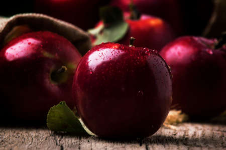 Small red apples on vintage wooden background, selective focusの写真素材