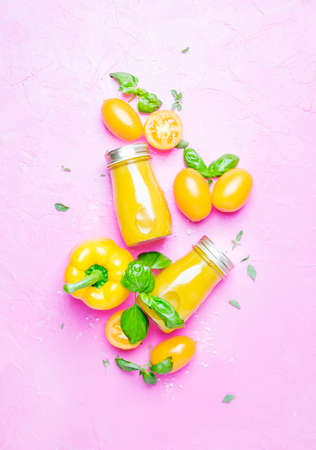 Yellow vegetable vegan juice on pink background, top viewの写真素材