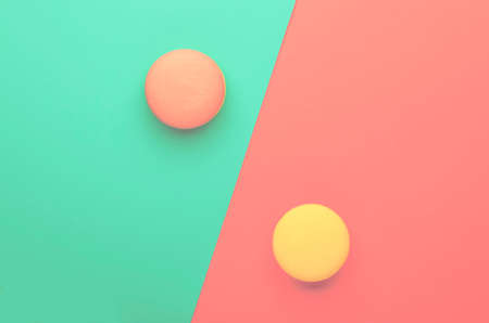 Pink yellow macaroons on blue pink graphic background, neon color, place for text, creative layout,...