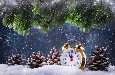 Christmas or New Year background with Golden alarm clock in snowdrifts on blue background with pine...