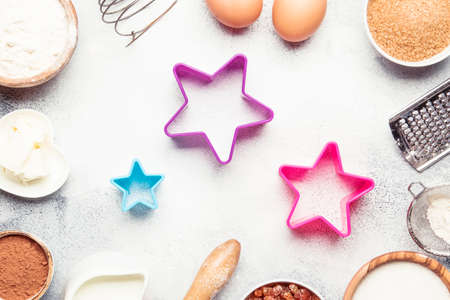 Christmas or New Year composition with ingredients for baking or cookies, with golden snowflakes, Christmas balls, on gray background, with baking form, frame, top viewの写真素材