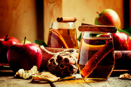 Apple juice with cinnamon in a glass and fresh apples on a vintage wooden background, selective focus and shallow depth of fieldの写真素材