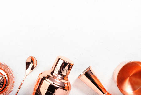 Copper bar tools and accessories for making cocktail. Shaker, jigger, strainer, spoon, tongs, muddler. Alcohol drink and beverages preparation concept. White background, top view, copy spaceの写真素材