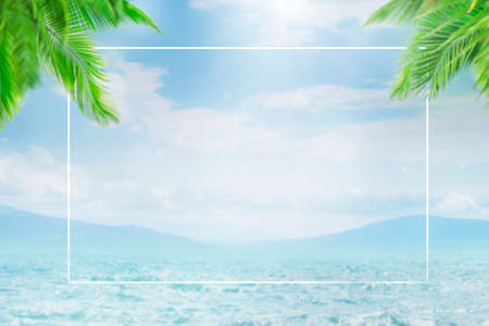 Blurred summer natural marine tropical blue background with palm leaves and sunbeams of light. White border frame. Sea and sky with white cloudsの写真素材