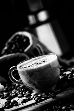 Coffee with milk, coffee maker, coffee beans, dark toned image, selective focusの写真素材