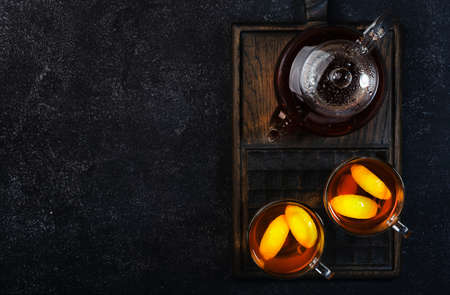 Healing black herbal tea with ginger, honey, lemon and sage. Immune booster drink in glass cup on black kitchen table background with copy space. Top viewの写真素材