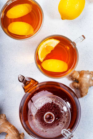 Healing black herbal tea with ginger, honey, lemon and mint. Immune booster drink in glass cup on...