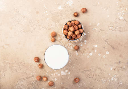 Vegan Hazelnut nut milk in bottles, closeup, beige table background. Non dairy alternative milk. Healthy vegetarian food and drink concept. Copy space, top viewの写真素材