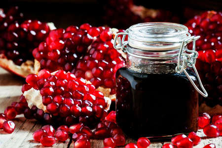 Pomegranate jam, fresh pomegranate, dark wood background, selective focus