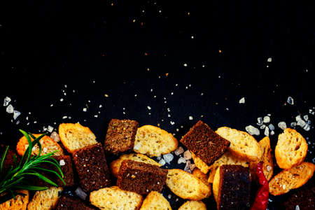 Unhealthy food concept, spicy salted crackers, dark background top viewの写真素材
