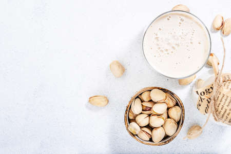 Vegan Pistachio nut milk in bottles, closeup, gray table background. Non dairy alternative milk. Healthy vegetarian food and drink concept. Copy space, top viewの写真素材