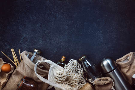 Zero waste, plastic free and sustainable lifestyle concept. Recyclable, reusable eco-friendly bags, package, bottles, cans and storage containers, mesh bag. Black background, copy space, top viewの写真素材