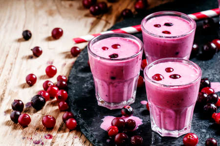 Pink smoothies with milk, black currants and cranberries, fresh berries on a dark background, selective focusの写真素材